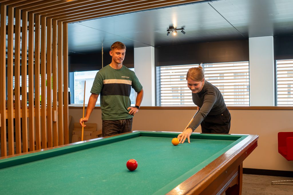 Collega's van REUS spelen samen een potje biljart op kantoor
