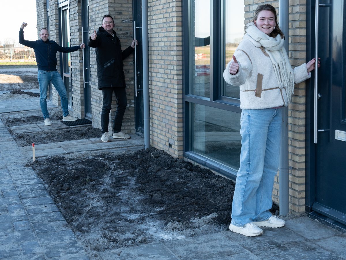 Nieuwe bewoners bij de voordeur van hun nieuwbouwwoning