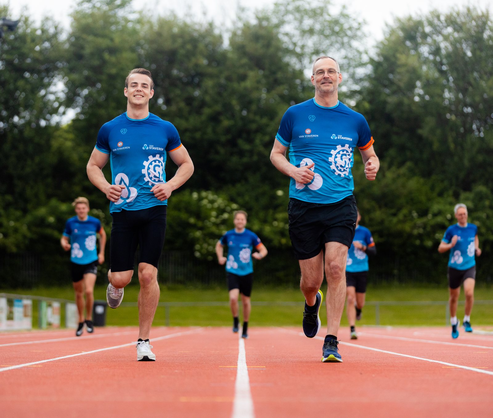 Collega's van Van Staveren hardlopen in shirts in de nieuwe huisstijl